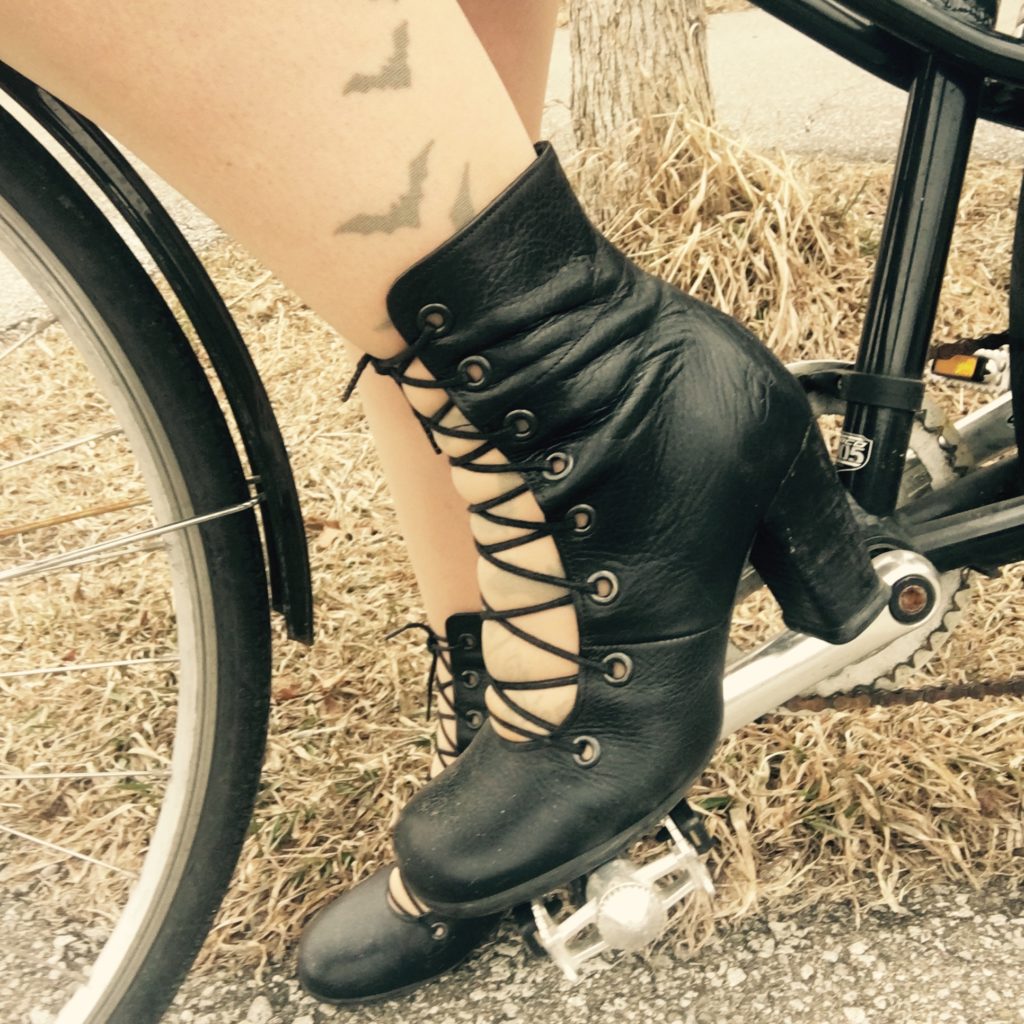 Woman's high heel boot on a bicycle pedal.