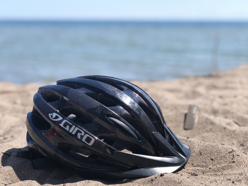 Bike helmet resting on beach sand in Toronto
